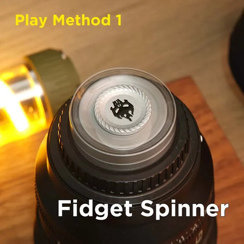 Close-up of a metal fidget spinner on a tabletop, labeled 'Play Method 1'.
