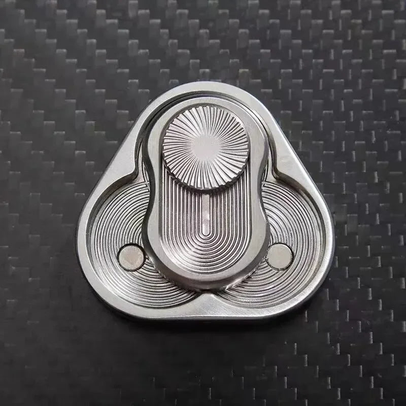 Metal fidget spinner with engraved geometric patterns on carbon fiber surface