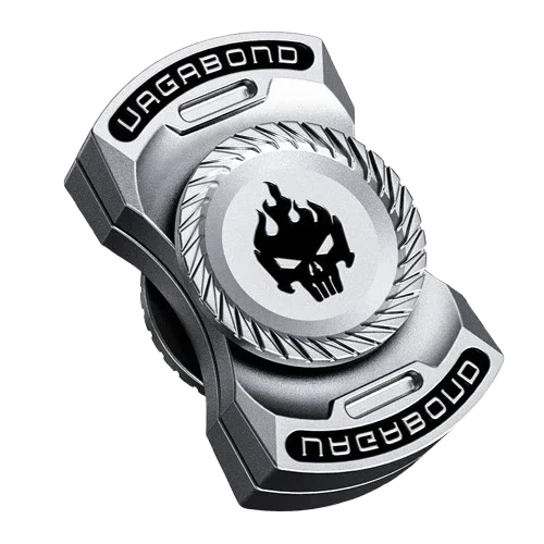 Silver metal fidget spinner with skull and flame design, engraved 'VAGABOND' text.